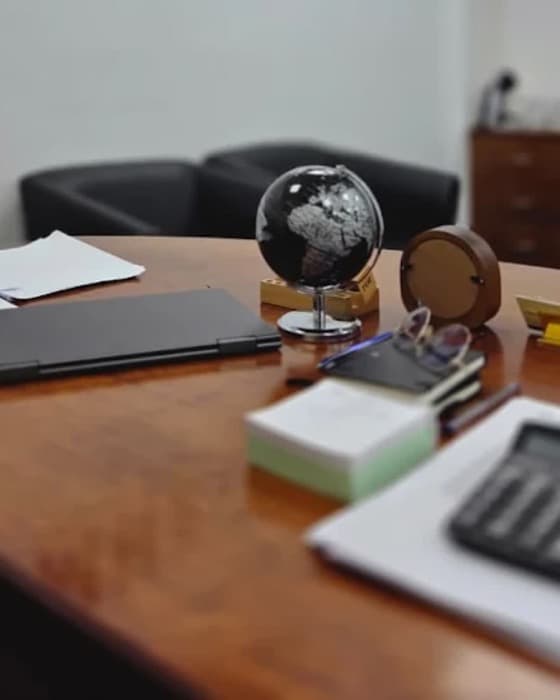 A desk globe beside a calculator and working papers