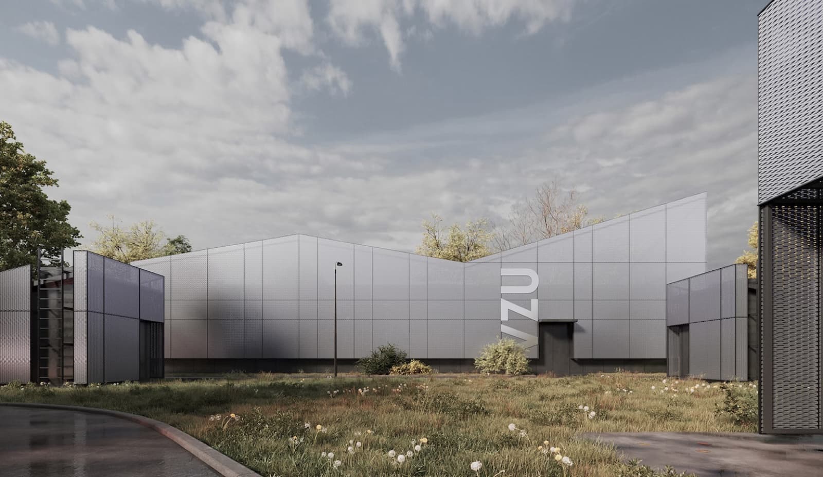 A grey metal-panelled institutional building under a broad sky